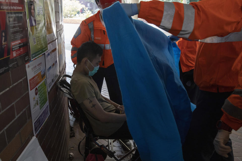 A man is evacuated by medics from the Hong Kong Polytechnic University in Hong Kong on Wednesday, Nov. 20, 2019. Hong Kong schools have reopened after a six-day shutdown but students were facing transit disruptions as the last protesters remained holed up on a university campus. (AP Photo/Ng Han Guan)