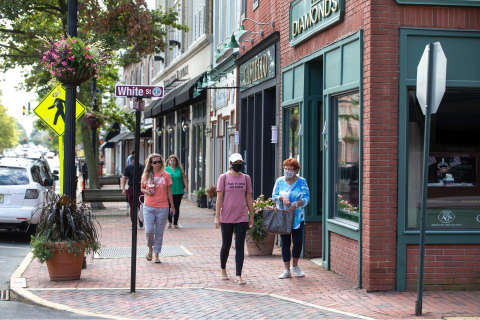 Folks walk along Broad Street near White Street midday. Construction continues on White Street as well as the parking lot adjacent to it in downtown Red Bank.  Red Bank, NJTuesday, September 1, 2020  