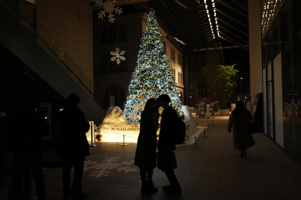 A woman and a man pose for their selfie by a Christmas tree on Christmas Eve in Tokyo, Saturday, Dec. 24, 2022. (AP Photo/Hiro Komae)