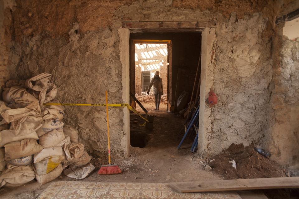 En esta imagen, tomada el 5 de abril de 2017, un trabajador pasa por el interior de una casa que está siendo renovada, en la zona colonial de Santo Domingo, República Dominicana. Con un préstamo de 120 millones de dólares del Banco Interamericano de Desarrollo (BID), de los cuales 90 millones aún están pendientes de aprobación en el Congreso, las autoridades de turismo dominicanas realizan el proyecto de restauración de la ciudad más ambicioso de las últimas décadas. (AP Foto/Tatiana Fernández)