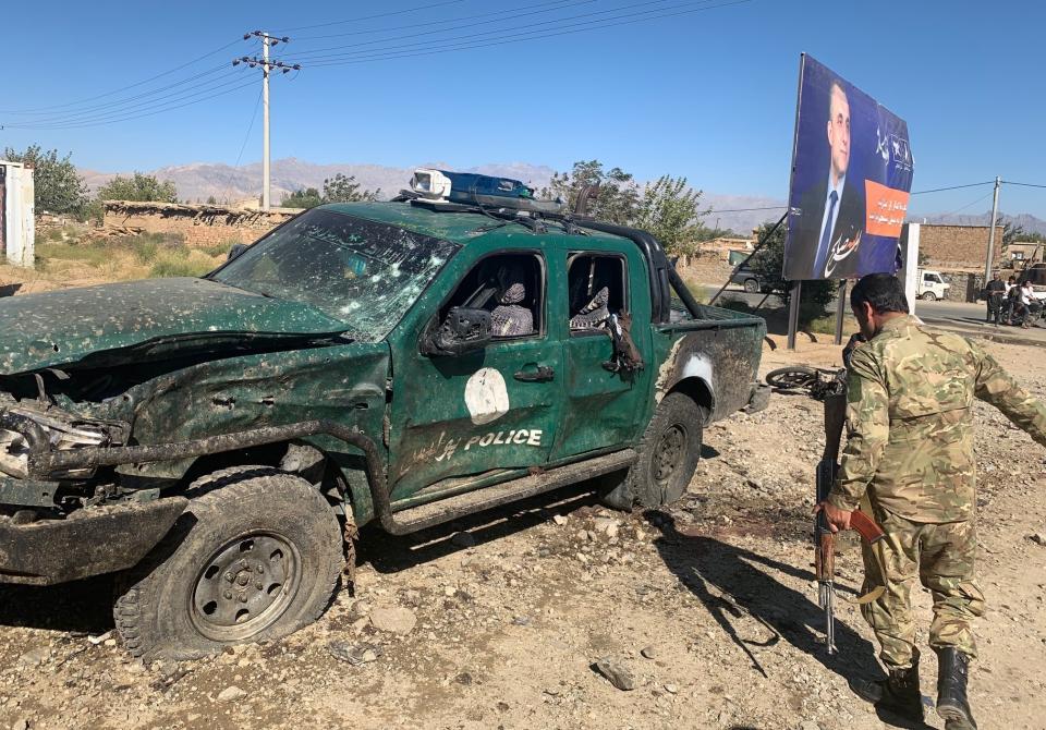 Afghan police inspect the site of a suicide attack, in Parwan province of Afghanistan, Tuesday, Sept. 17, 2019. The Taliban suicide bomber on a motorcycle targeted a campaign rally by President Ashraf Ghani in northern Afghanistan on Tuesday, killing over 20 people and wounding over 30. Ghani was present at the venue but was unharmed, according to his campaign chief. (AP Photo/Rahmat Gul)