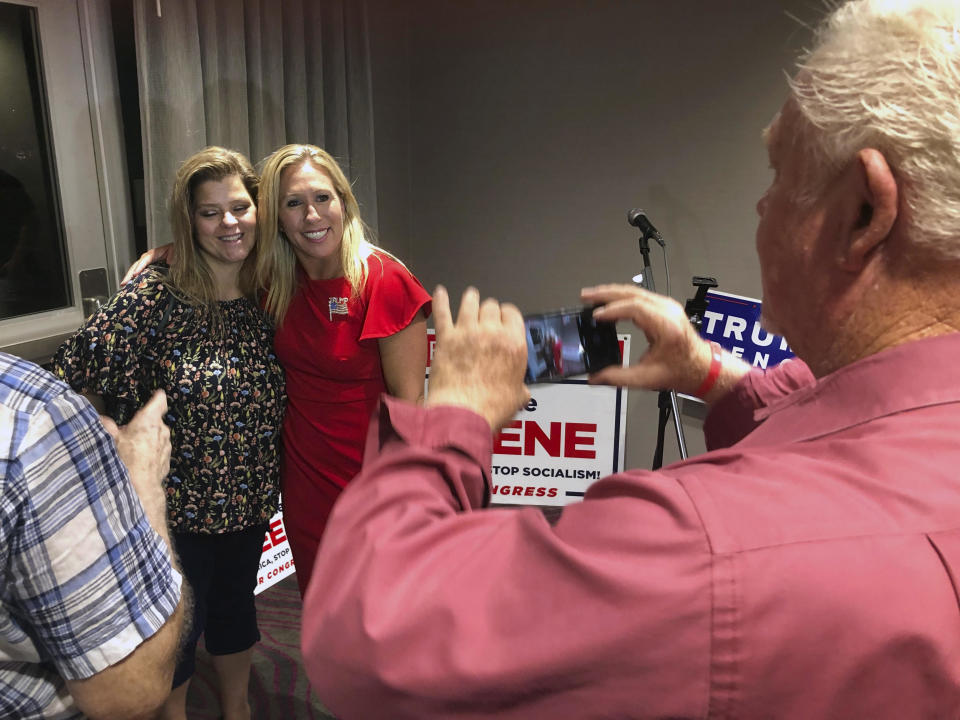 Supporters take photos with construction executive Marjorie Taylor Greene, background right, late Tuesday, August 11, 2020, in Rome, Georgia.  / Credit: Mike Stewart / AP