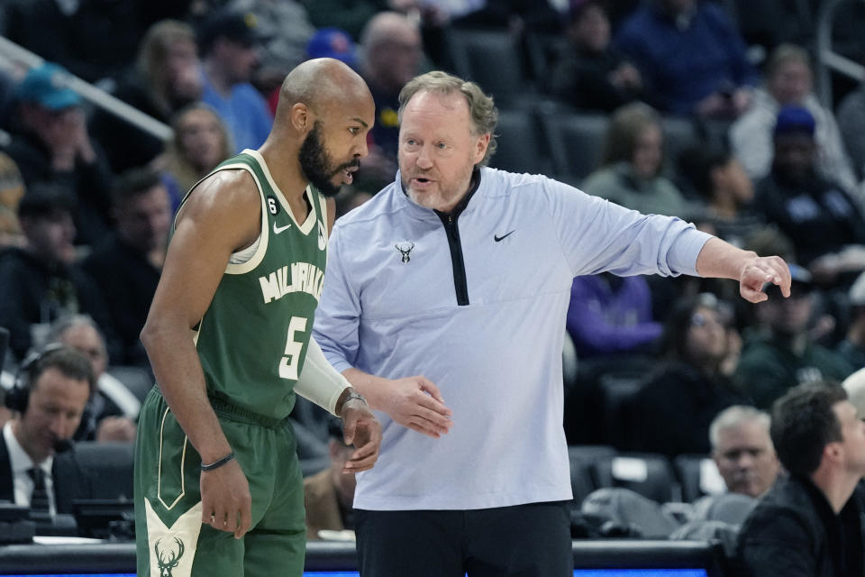 Milwaukee Bucks head coach Mike Budenholzer talks to guard Jevon Carter (5) during the first half of an NBA basketball game against the Detroit Pistons, Monday, March 27, 2023, in Detroit. (AP Photo/Carlos Osorio)