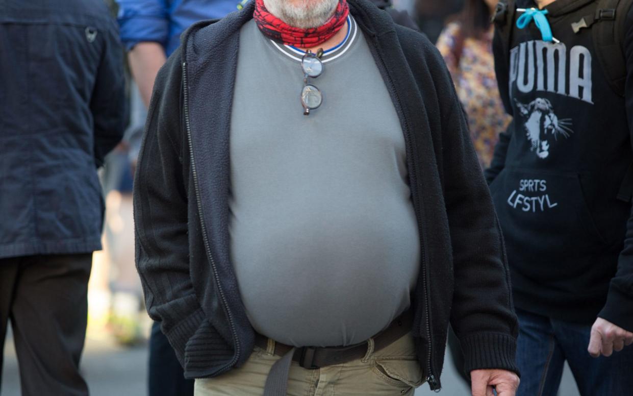 a man with a large stomach in a busy street