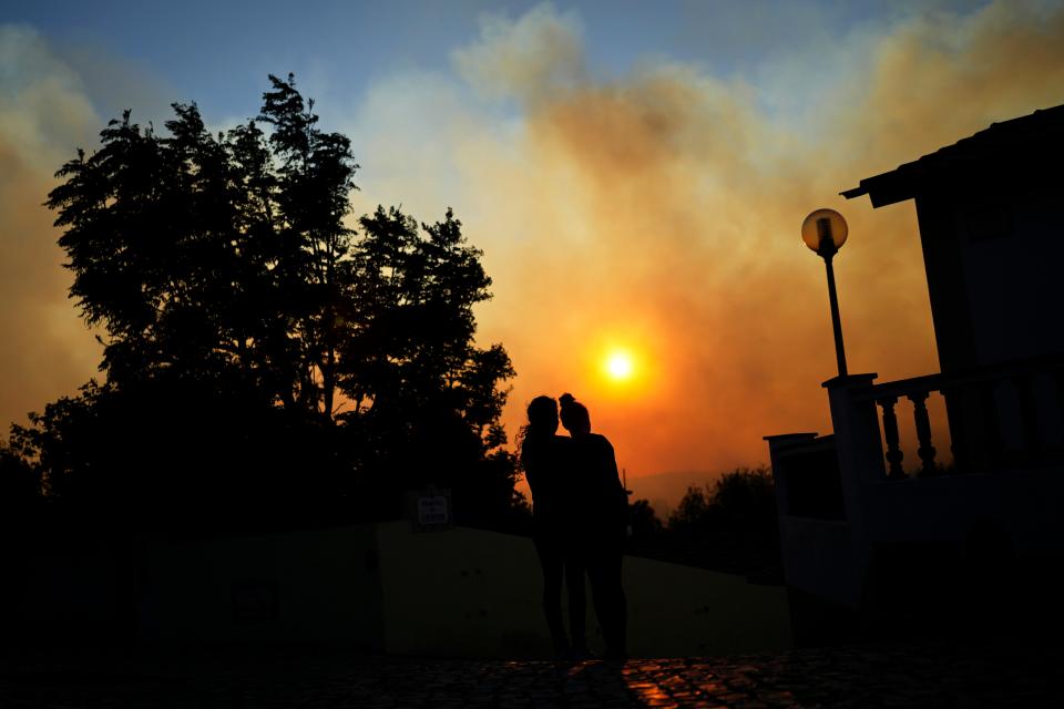 Two women watch a wildifire near Lisbon in Portugal (Copyright 2023 The Associated Press. All rights reserved)