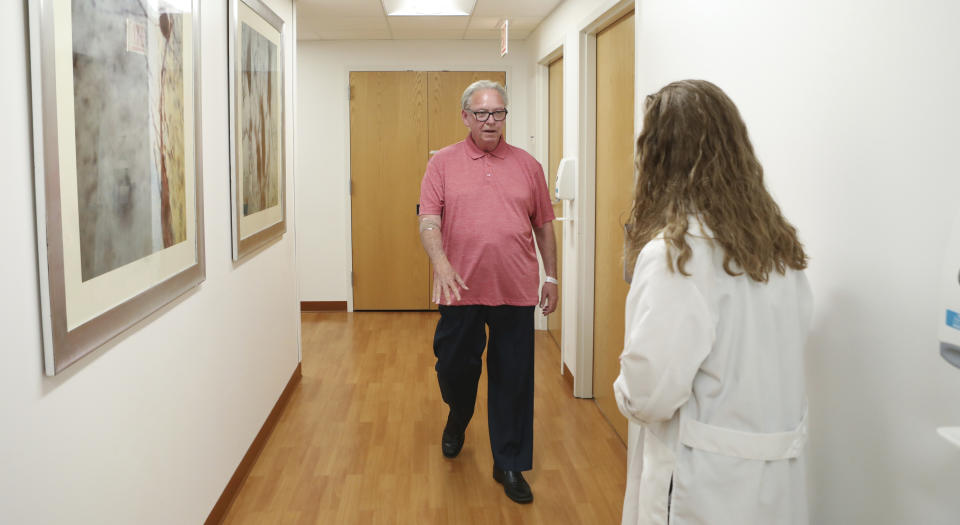 In this July 9, 2019 photo, Dr. Jori Fleisher, neurologist, examines Thomas Doyle, 66, at the Rush University Medical Center in Chicago. Doyle, 66, hopes blood tests may someday replace the invasive diagnostic testing he endured to be diagnosed 4.5 years ago with Lewy body dementia. (AP Photo/Teresa Crawford)