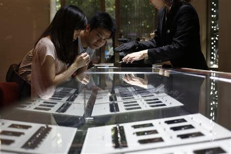 A couple selects diamond rings at a Tiffany store in Shanghai, September 16, 2013. REUTERS/Aly Song