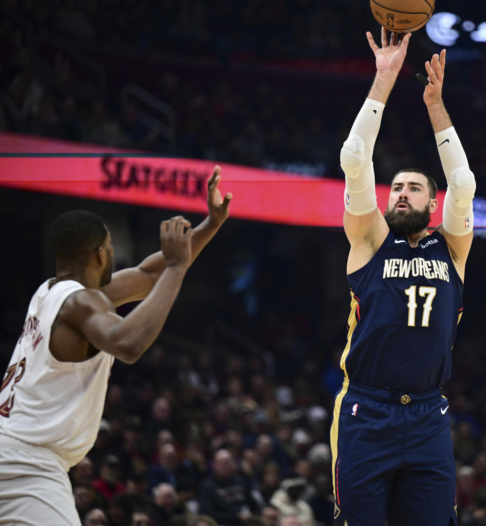 New Orleans Pelicans center Jonas Valanciunas shoots from 3-point range over Cleveland Cavaliers center Tristan Thompson during the first half of an NBA basketball game Thursday, Dec. 21, 2023, in Cleveland. (AP Photo/David Dermer)