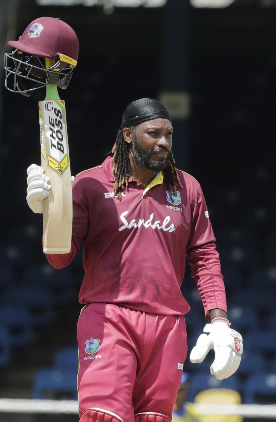 West Indies opener Chris Gayle raises his bat to the crowd after reaching a half century on the third One-Day International cricket match India in Port of Spain, Trinidad, Wednesday, Aug. 14, 2019. (AP Photo/Arnulfo Franco)