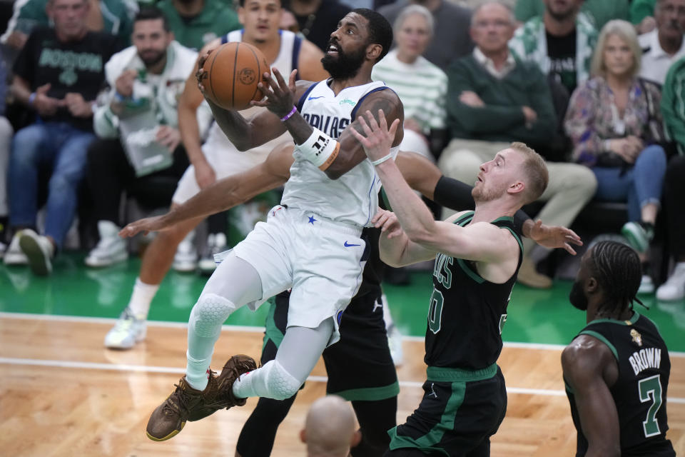 Dallas Mavericks guard Kyrie Irving, front left, drives to the basket past Boston Celtics forward Sam Hauser, second from right, during the first half of Game 2 of the NBA Finals basketball series, Sunday, June 9, 2024, in Boston. (AP Photo/Steven Senne)