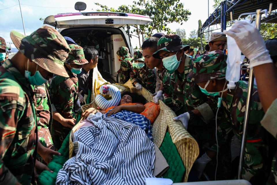 <p>Indonesian police and soldiers evacuate a woman after arriving at Tanjung hospital after earthquake hit on Sunday in North Lombok, Indonesia on Friday, Aug. 7, 2018. (Photo: Garry Lotulung/NurPhoto via Getty Images) </p>