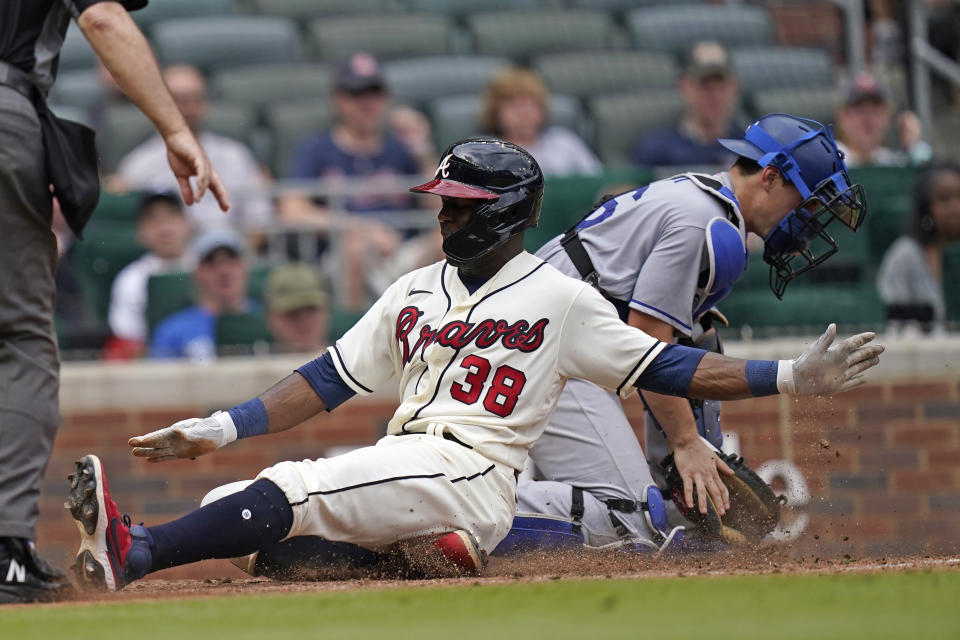 Atlanta Braves' Guillermo Heredia (38) scores ahead of the throw to Los Angeles Dodgers catcher Will Smith, right, on a sacrifice fly by Ender Inciarte in the eighth inning of a baseball game Sunday, June 6, 2021, in Atlanta. (AP Photo/Brynn Anderson)