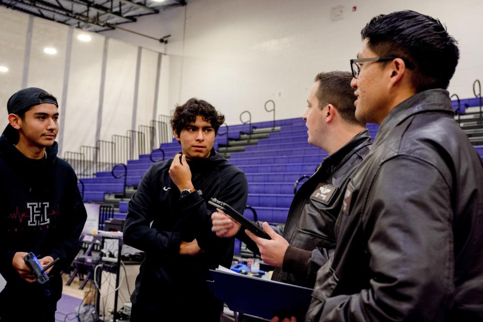 Airmen from the 29th Attack Squadron discuss the scoring process with students from the J.M. Hanks High School robotics team, out of El Paso, Texas, during the first Aerial Drone Competition at Mescalero Apache High School, Jan. 21, 2023. The 29th Attack Squadron served as judges and referees for this event, as well as mentors for the students, providing guidance throughout the competition.