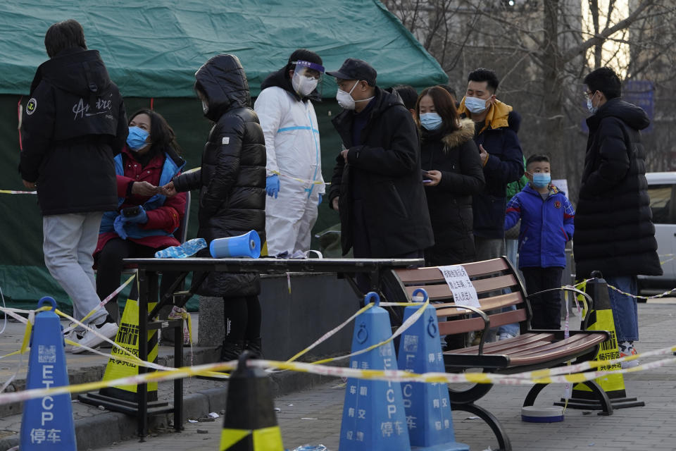 Residents line up for coronavirus tests at tents set up on the streets of Beijing on Sunday, Dec. 27, 2020. Beijing has urged residents not to leave the city during the Lunar New Year holiday in February, implementing new restrictions and mass testings after several coronavirus infections last week. (AP Photo/Ng Han Guan)