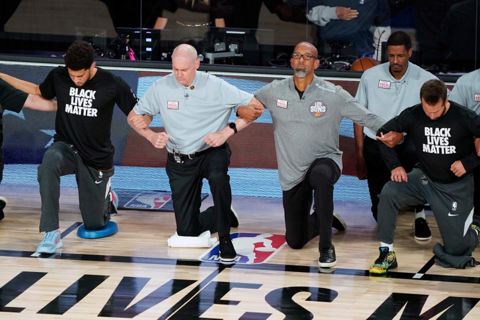 Aug 13, 2020; Lake Buena Vista, Florida, USA; Phoenix Suns head coach Monty Williams, second from right, and Dallas Mavericks head coach Rick Carlisle, second from left, kneel with players before the start of an NBA basketball game Thursday, Aug. 13, 2020 in Lake Buena Vista, Fla. at ESPN Wide World of Sports Complex. Mandatory Credit: Ashley Landis/Pool Photo-USA TODAY Sports