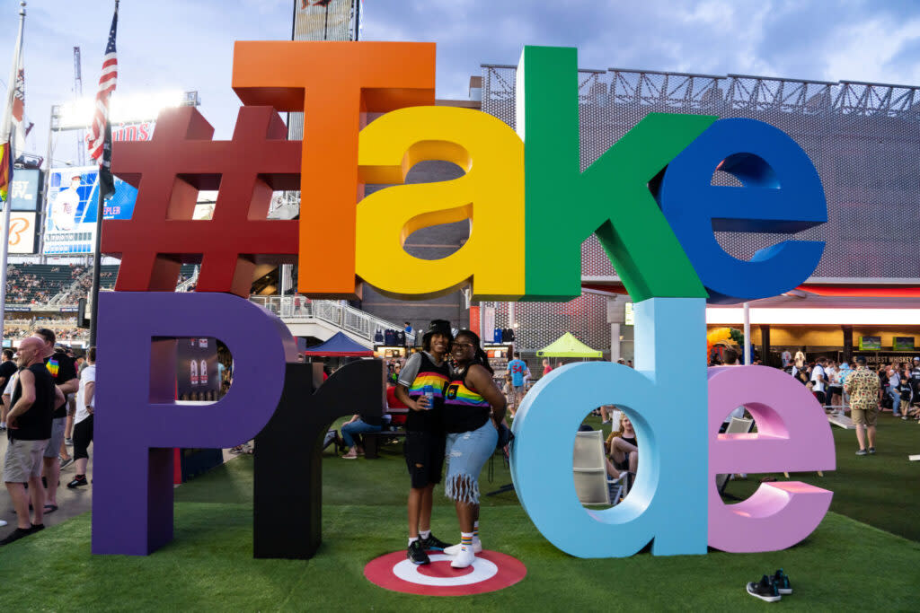 Fans pose for a photo in front of a Pride sign in the fifth inning of the game between the Chicago White Sox and Minnesota Twins at Target Field in Minneapolis.