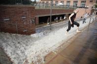 A man walks through flood water up stairs from a parking structure outside UCLA's Pauley Pavilion sporting arena as water flows from a broken thirty inch water main that was gushing water onto Sunset Boulevard near the UCLA campus in the Westwood section of Los Angeles July 29, 2014. The geyser from the 100-year old water main flooded parts of the campus and stranded motorists on surrounding streets. REUTERS/Danny Moloshok