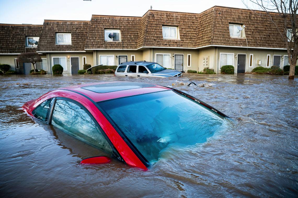 Floodwaters course through a neighborhood in Merced, Calif., on Tuesday, Jan. 10, 2023. Following days of rain, Bear Creek overflowed its banks leaving dozens of homes and vehicles surrounded by floodwaters. (AP Photo/Noah Berger)