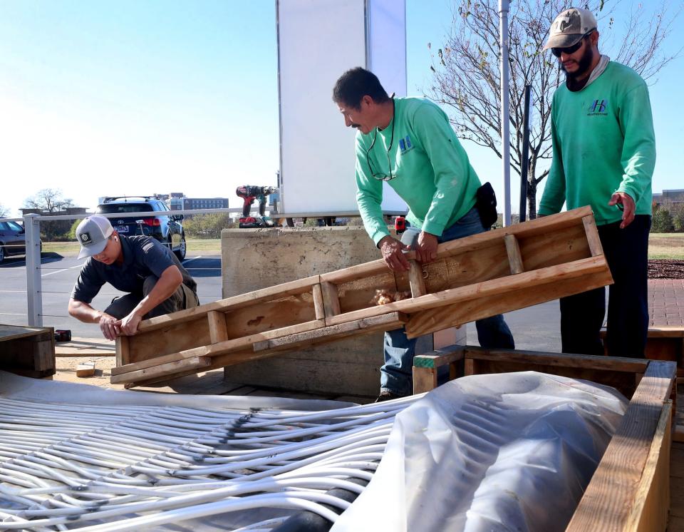 Jeremy Hartono, left, Manuel Linares, middle, and Marvin Pena, right, build a platform around the ice rink it is being assembled for Winterfest 2022 at Fountains at Gateway, on Wednesday, Nov. 9, 2022.