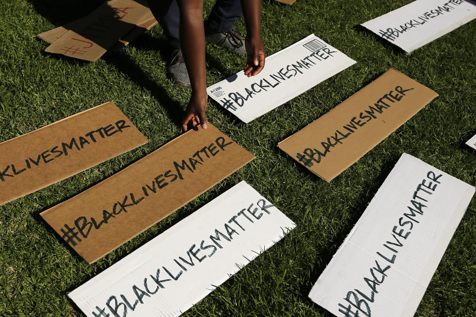 FILE - In this July 17, 2013, photo, a protester picks up signs during a demonstration in reaction to the acquittal of neighborhood watch volunteer George Zimmerman in Beverly Hills, Calif. The Black Lives Matter movement emerged amid anger over the acquittal of Zimmerman, the Florida man who shot and killed 17-year-old Trayvon Martin in 2012 after Zimmerman assumed the black teen was a potential burglar. (AP Photo/Jae C. Hong, File)