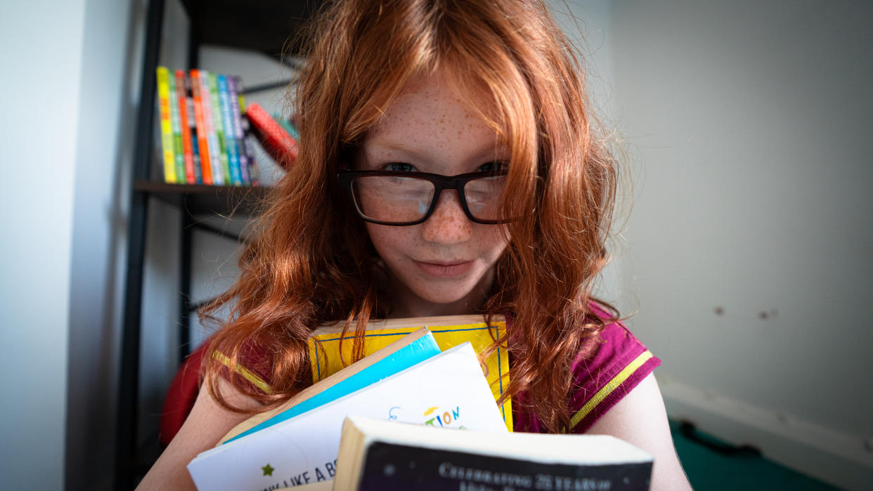 Elissa holds a stack of books