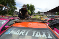 Workers from two taxi cooperatives assemble miniature gardens on the rooftops of unused taxis parked in Bangkok, Thailand, Thursday, Sept. 16, 2021. Taxi fleets in Thailand are giving new meaning to the term “rooftop garden,” as they utilize the roofs of cabs idled by the coronavirus crisis to serve as small vegetable plots and raise awareness about the plight of out of work drivers. (AP Photo/Sakchai Lalit)