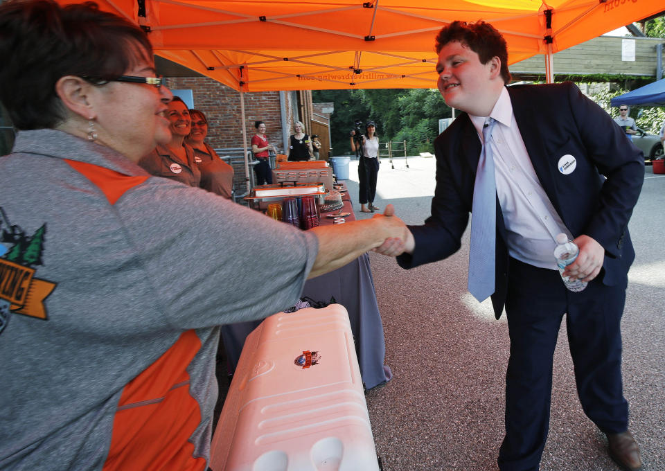 Vermont Democratic gubernatorial candidate Ethan Sonneborn, who is a 14-year old student, shakes hands with Martha Gagner, who works for a brewery catering his election night party, in Winooski, Vt., Tuesday, Aug. 14, 2018. Sonneborn has taken advantage of a quirk in state law that doesn't require gubernatorial candidates to be registered voters. (AP Photo/Charles Krupa)