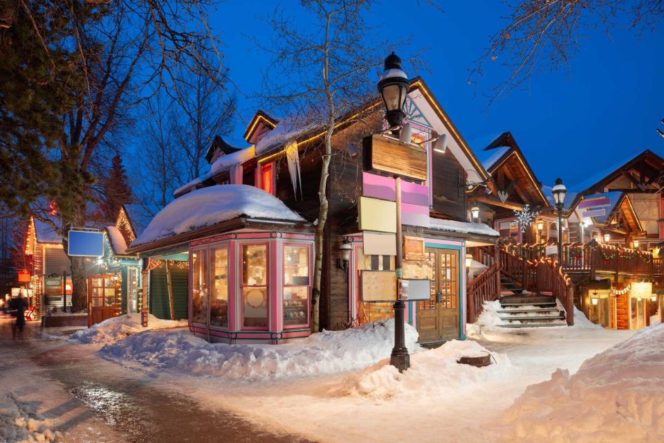 Breckenridge, Colorado downtown streets at night in the winter with holiday lighting.