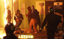 Rioters stand off police as they surge through a retail estate on Saturday in Tottenham, North London.