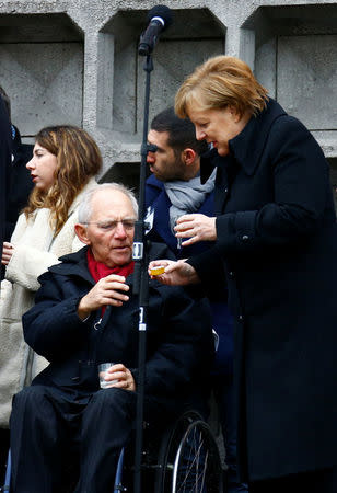 German Chancellor Angela Merkel and Bundestag's President Wolfgang Schaeuble attend the inauguration of memorial at the site of last year's truck attack in a Christmas market, which killed 12 people and injured many others, at Breitscheidplatz square in Berlin, Germany December 19, 2017. REUTERS/Fabrizio Bensch