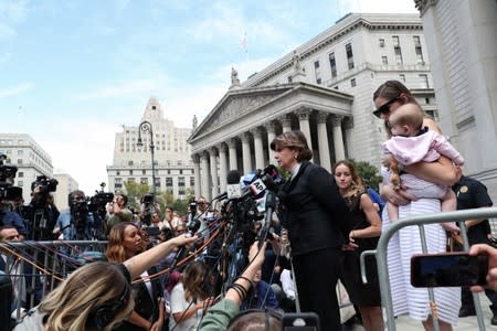 Allred, who is representing alleged victims, speaks to the media with Davies, an alleged victim of Epstein, and an unidentified woman and baby after a hearing in New York