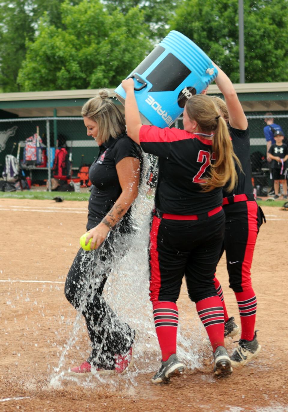 Oak Hills head coach Jackie Cornelius-Bedel gets the water bath treatment after the OHSAA softball tournament game between Oak Hills and Lebanon high schools May 19, 2022, at Mason High School.