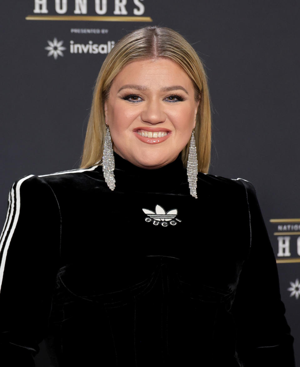 Close-up of Kelly smiling and wearing long, dangly, bejeweled earrings