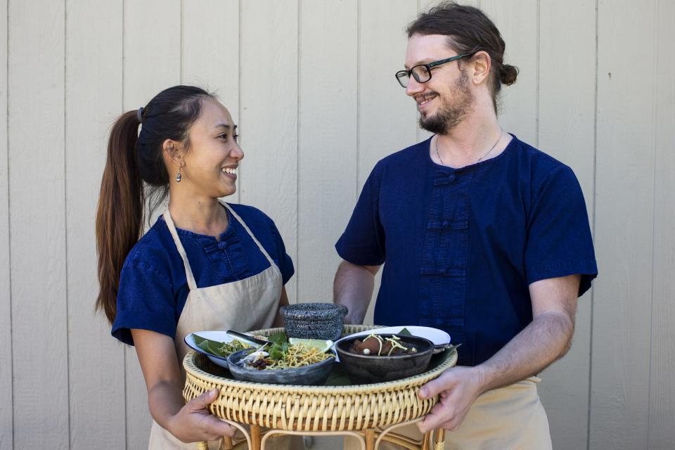 Yotaka and Alex Martin stand for a portrait with an arrangement of Thai dishes on Dec. 15, 2020, in Scottsdale. The Martins cook Thai cuisine for their food pop-up, Lom Wong, which is currently available for pickup once a week.