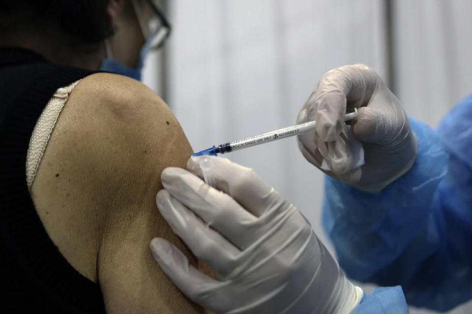 A woman receives a Pfizer COVID-19 vaccine at Saint George Hospital University Medical Center, in Beirut, Lebanon, Tuesday, April 6, 2021. Human Rights Watch, a leading rights group, said that Lebanon's vaccination campaign has been slow and risks leaving behind some of the country's most vulnerable people, including Palestinian and Syrian refugees, as well as migrant workers. (AP Photo/Bilal Hussein)