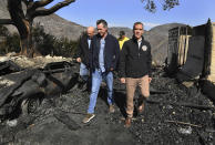 From left, L.A. City Councilman Mike Bonin, California Governor Gavin Newsom and L.A. City Mayor Eric Garcetti tour a burned home along Tigertail Road in Brentwood, Calif., Tuesday Oct. 29, 2019. (Wally Skalij/Los Angeles Times via AP, Pool)