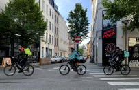 Three bicycle couriers deliver meals, during a partial lockdown to prevent the spread of the coronavirus, COVID-19, in Antwerp, Belgium, Thursday, April 30, 2020. (AP Photo/Virginia Mayo)