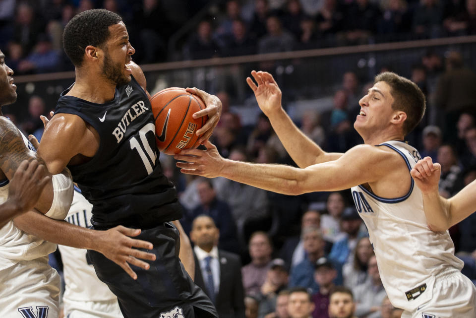 Butler forward Bryce Nze (10) and Villanova guard Collin Gillespie (2) grapple for a rebound during the second half of an NCAA college basketball game, Tuesday, Jan. 21, 2020, in Villanova, Pa. Villanova won 76-61. (AP Photo/Laurence Kesterson)