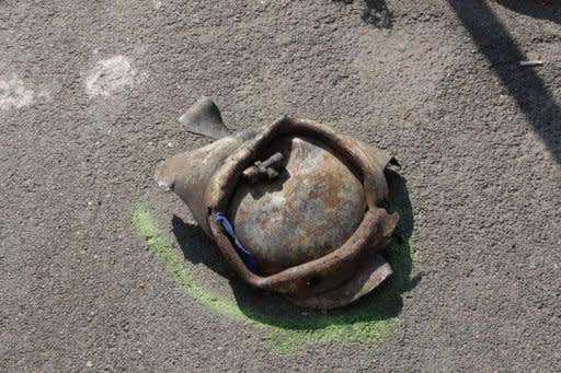 A piece of a gas canister used as a bomb is seen on the ground after a blast near a school in Brindisi. The blast went off outside the building as students were arriving for class at the all-girls Francesca Morvillo Falcone vocational school