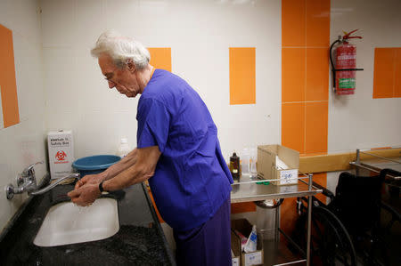 British vascular surgeon John Wolfe, who was invited to Gaza by the International Committee of the Red Cross (ICRC), washes his hands as he works in a hospital in Gaza City April 24, 2018. REUTERS/Suhaib Salem