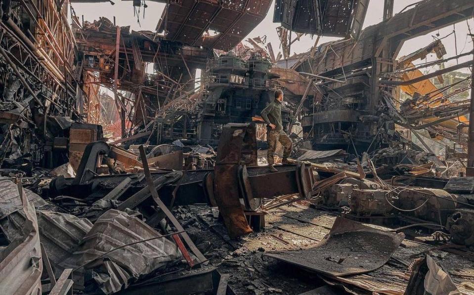 A Ukrainian soldier poses among the twisted structures and debris of the ruined Mariupol steelworks