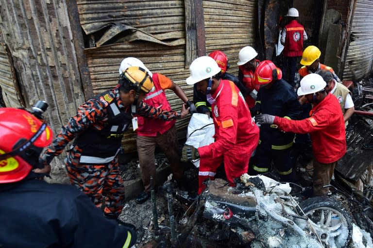 Socorristas resgatam o corpo de uma vítima do incêndio em edifícios residenciais em Daca, que deixou mais de 60 mortos, em 20 de fevereiro de 2019