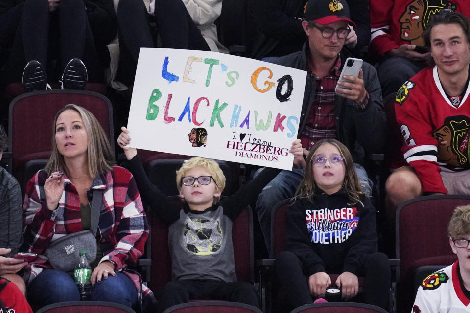 A Chicago Blackhawks fan holds a sign during the third period of an NHL hockey game against the Seattle Kraken in Chicago, Sunday, Oct. 23, 2022. The Blackhawks won 5-4.(AP Photo/Nam Y. Huh)