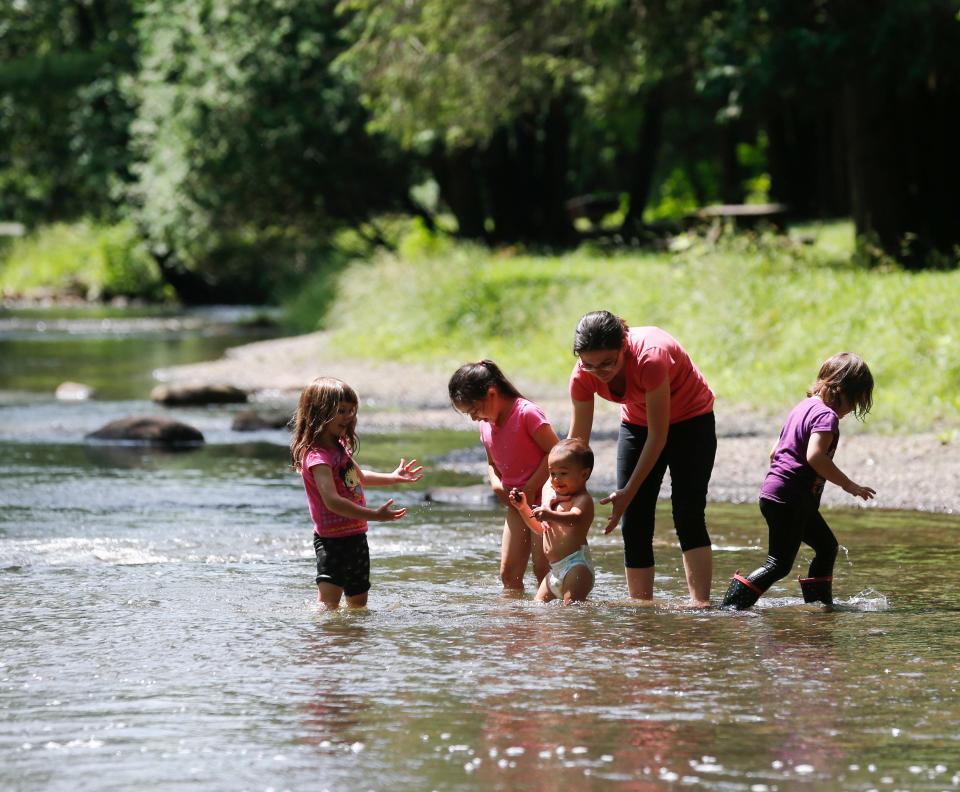 Visitors to Saratoga Spa State Park cool off in Geyser Creek in Saratoga Springs, N.Y.