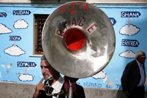 A band player prepares for another funeral ceremony in Riace, whose elderly population is dying off