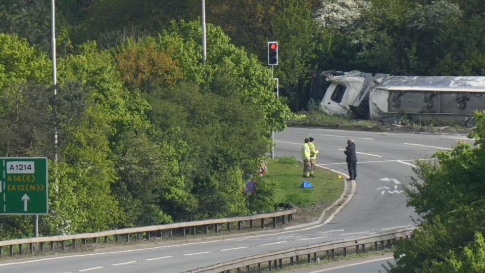 Tanker on its side by the road.