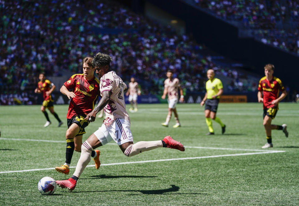 Portland Timbers forward Dairon Asprilla, front right, looks to chip the ball ahead of Seattle Sounders defender Cody Baker, left, during the first half of an MLS soccer match, Saturday, June 3, 2023, in Seattle. (AP Photo/Lindsey Wasson)