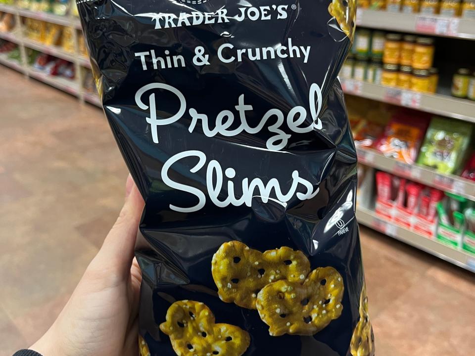 hand holding up a bag of thin and crunchy pretzel slims at trader joe's