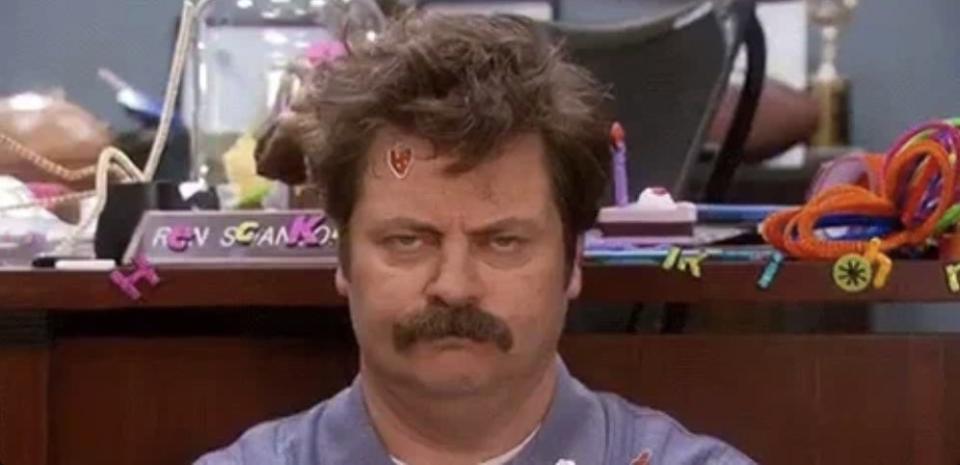 Nick Offerman, with toys and crafts scattered around, appears unimpressed in an office setting