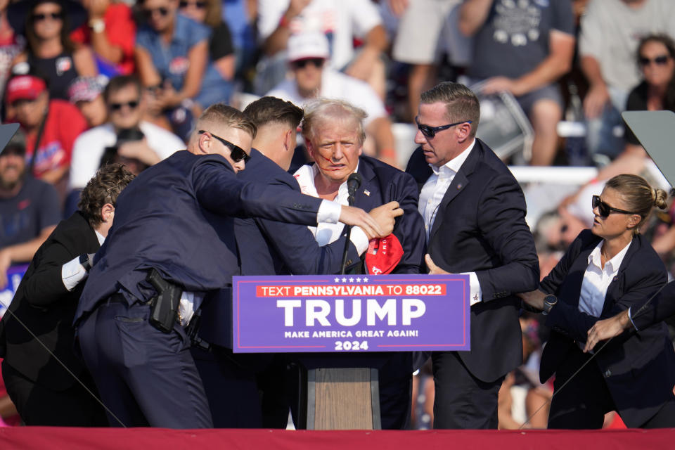 El expresidente y virtual candidato presidencial republicano Donald Trump recibe ayuda para bajar del estrado en un mitin de campaña en Butler, Pensilvania, el sábado 13 de julio de 2024. (AP Foto/Gene J. Puskar)